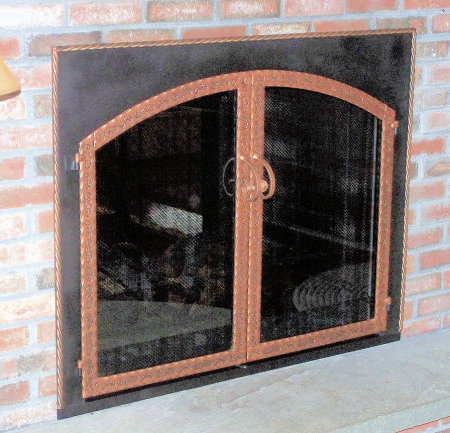The Hyannisport Square to Arch Black frame with antique copper twisted molding, scrolled steel twin doors, with standard forged center handles,  smoke glass. Comes with slide mesh spark screen  (Second side of a see through fireplace.)